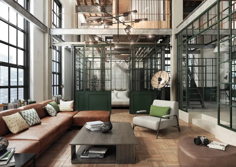 Loft industriel spacieux avec de grandes fenêtres, canapé en cuir marron, décoration moderne et coin salon séparé. Les tons chauds créent une atmosphère chaleureuse.