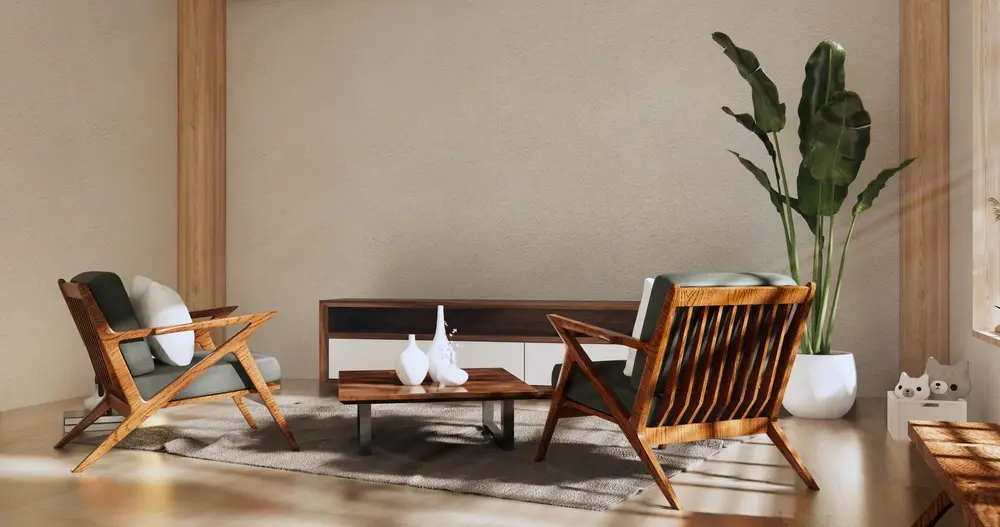 Un salon minimaliste avec deux fauteuils en bois face à une table basse et une console en bois foncé. Une grande plante en pot et des figurines de chats apportent une touche chaleureuse.